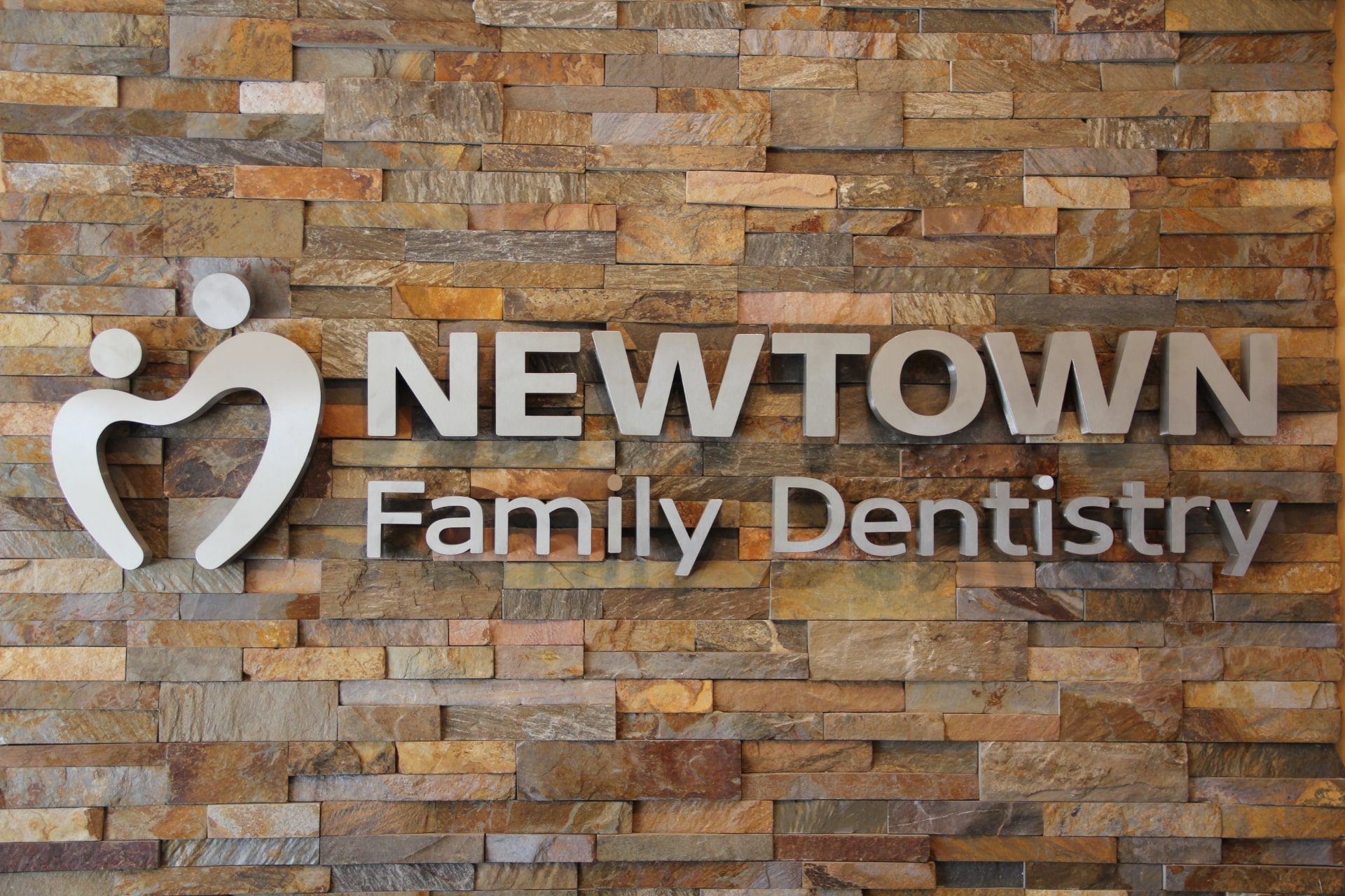 Norstone Ochre XL stacked stone feature wall with stainless steal signage in a Dentist Office in Delaware